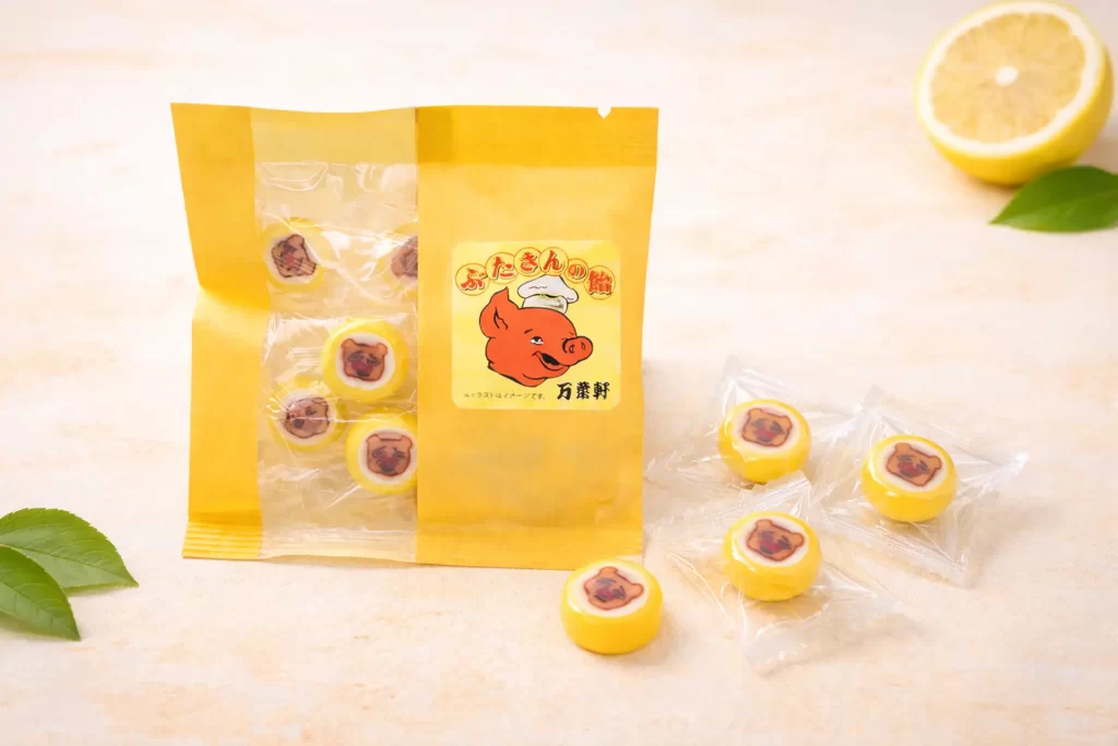 千葉の老舗駅弁ブランド「万葉軒」、人気キャラ”ぶたさん”の金太郎飴が登場―レモン味で旅のお供に